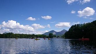 磐梯山を背に進む色とりどりのカヤック（23日午後のカヤック体験）